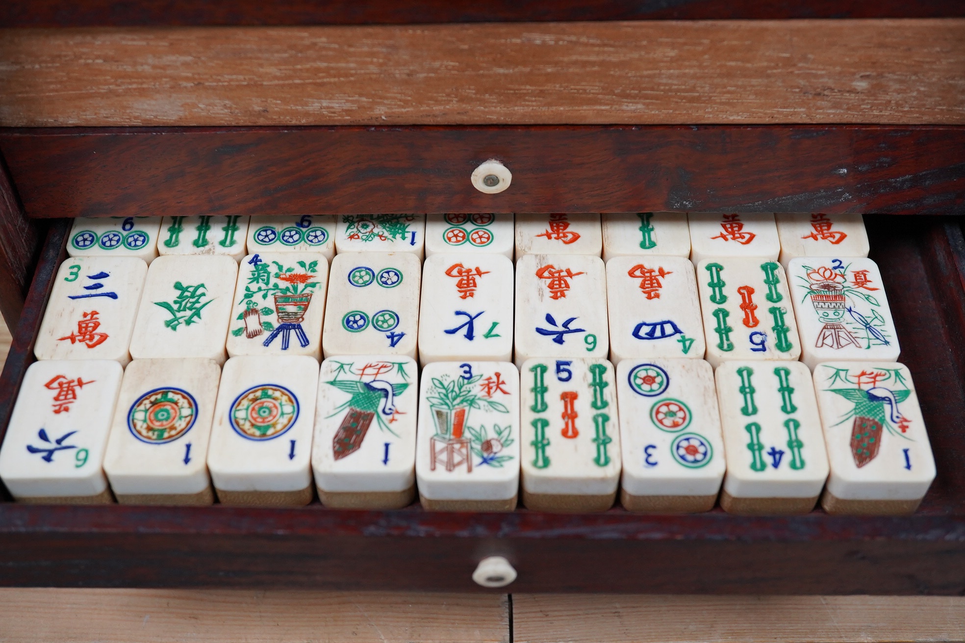 An early 20th century Chinese Mah Jong set, with bone tiles, 22cm x 15.5cm x 14.5cm. Condition - fair, one drawer front replaced